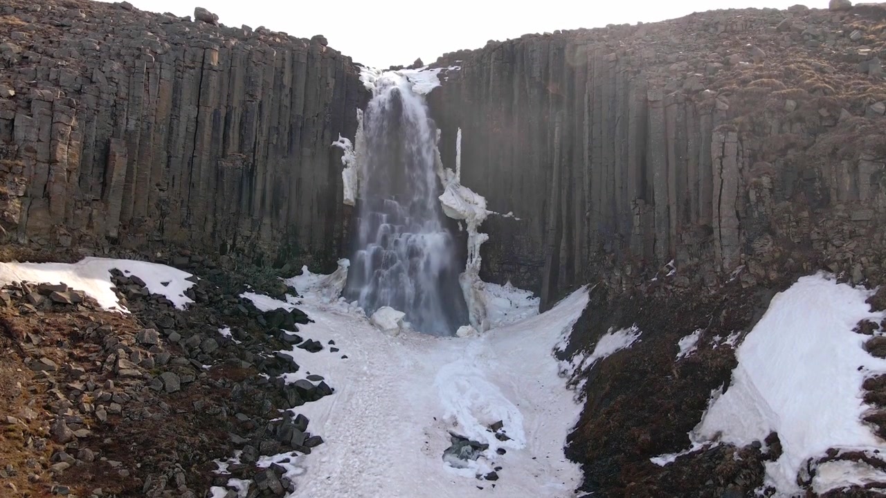 Stuolafoss waterfall in Iceland covered in snow.