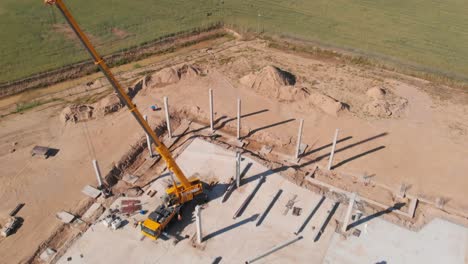 construcción de una sala, suelo de hormigón, columnas y una grúa de pie
