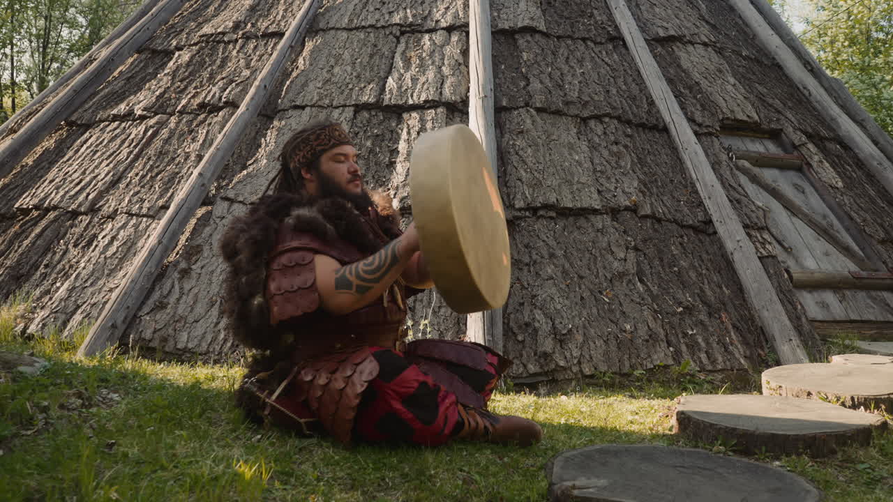 hombre obeso repara tambor chamánico sentado cerca de anciano ail