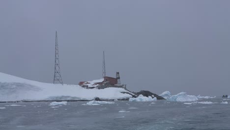 paisaje de la antártida en un día nevado, edificio de la estación de investigación base y torre, hielo flotante y costa en la niebla 60 fps