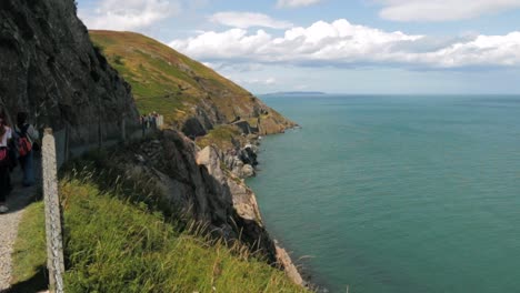 People-hiking-along-the-coast-on-a-warm,-sunny-day