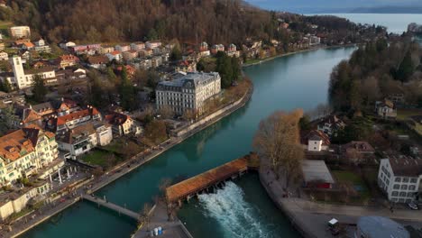 flowing river aare sluice in thun old town, lake thun and alps beyond