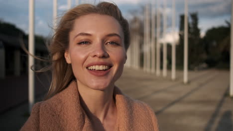 una mujer rubia mirando a la cámara al aire libre.