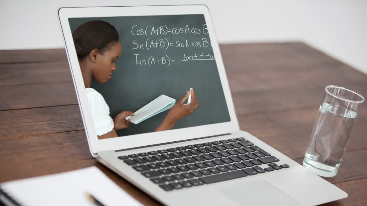 Animation of a laptop showing biracial female teacher on the screen