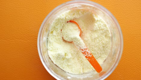 close up of baby milk powder and spoon on tile background