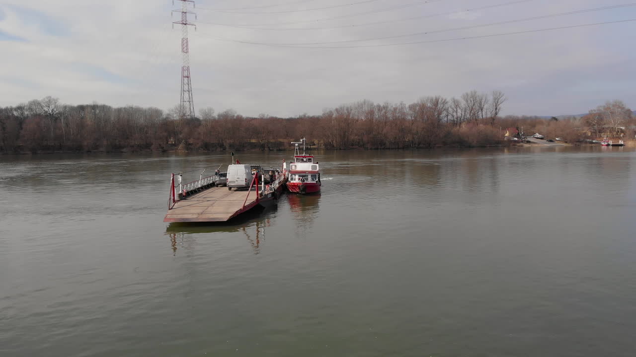 toma aérea orbital alrededor de un transbordador en un río, cargado de autos y personas