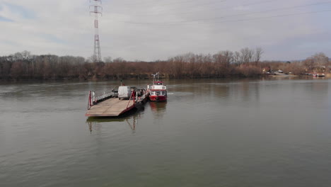 orbital aerial shot around a ferry boat on a river, loaded with cars and people