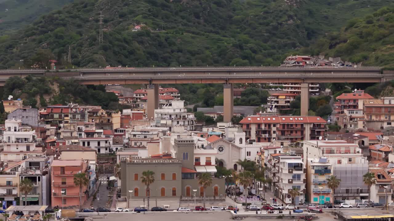 Charming coastal town with hillside homes and a bridge in Letojanni, Sicily, Italy