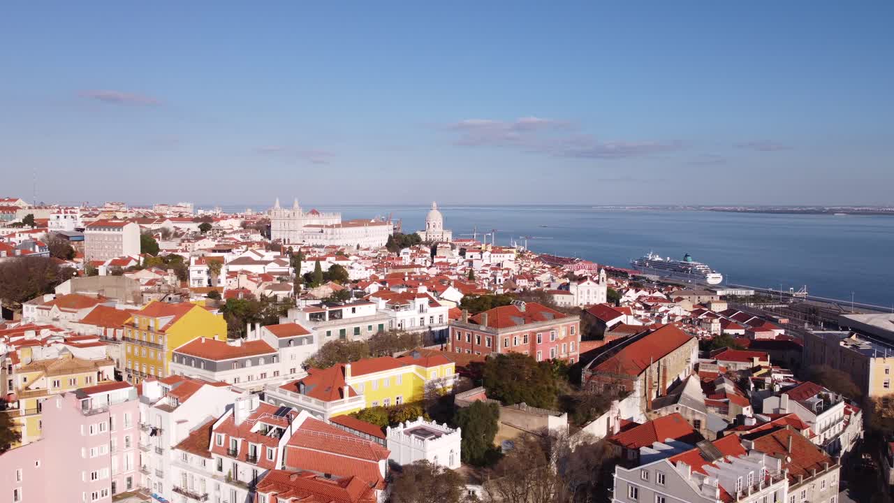 Drone che sorvola lateralmente la baia su Alfama, Lisbona, Portogallo in una luminosa e soleggiata giornata invernale in Europa
