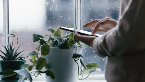 close-up-woman-hands-using-digital-tablet-computer-browsing-online-messages-reading-social-media-enjoying-mobile-touchscreen-device-standing-by-window-relaxing-at-home-on-cold-rainy-day