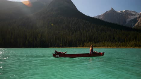 vista lateral de una joven pareja en un barco de remo en un río turquesa 4k