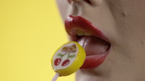 mujer lamiendo helado con su lengua, boca en primer plano en fondo amarillo