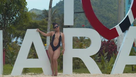 una chica latina sexy parada junto al cartel de i love maracas en la isla caribeña de trinidad
