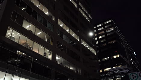 Walking-in-The-Street-Of-Downtown-Montreal-With-City-Buildings-illuminated-At-Night-In-Quebec,-Canada-During-Pandemic-Coronavirus