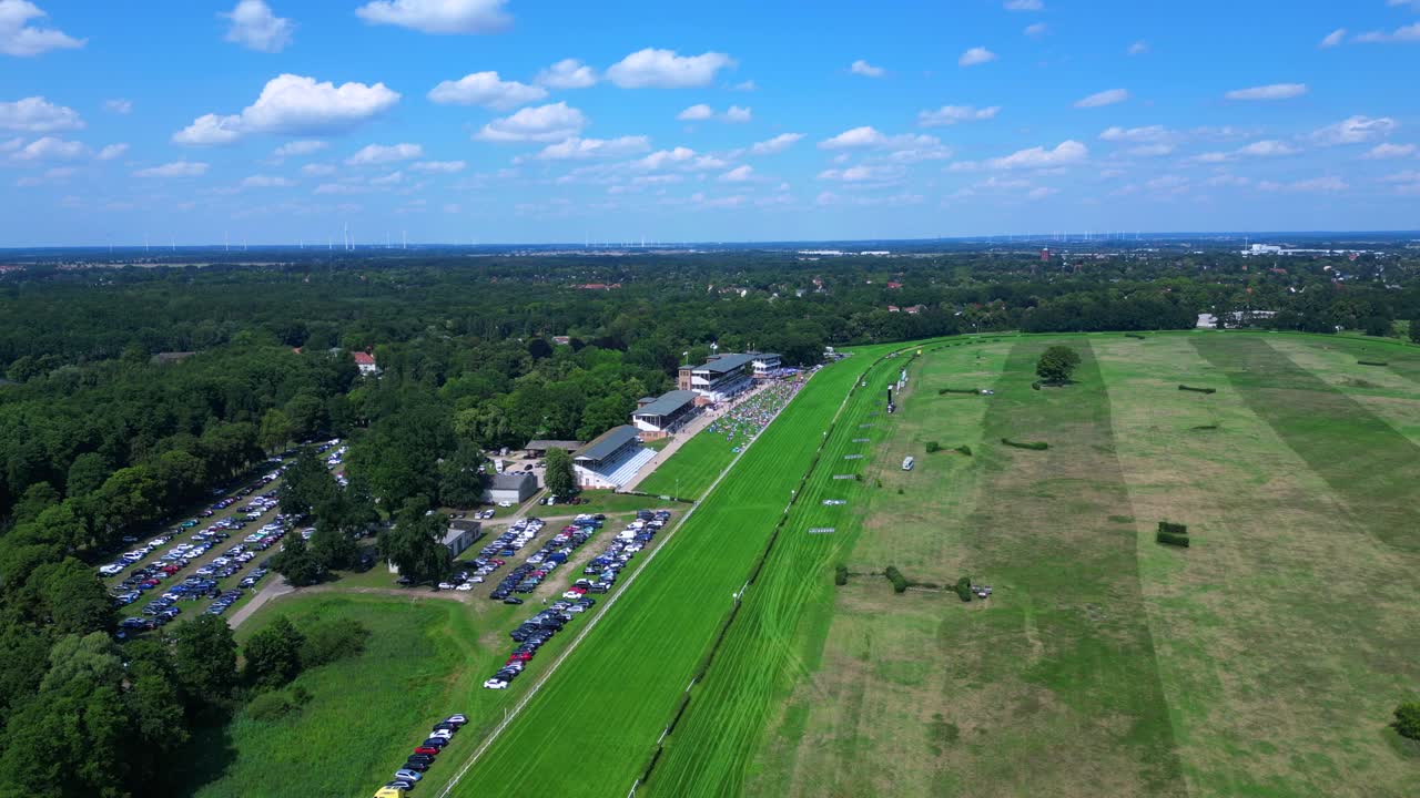 horse racing track with spectators enjoying the competition on a sunny summer day. Best aerial view flight drone shot footage from above