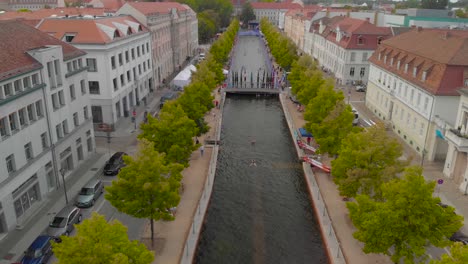 Vista-Aérea-De-Atletas-Remando-Para-Una-Competencia-De-Kayak-En-Canoa-En-El-Canal-De-La-Ciudad-De-Potsdam