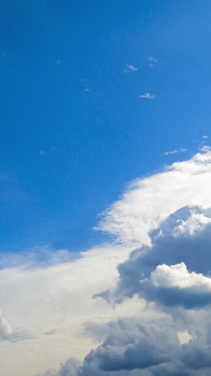 Bright white shining clouds lit by the hot summer sun. Cumulus and spindrift clouds moving in the sky timelapse. Vertical video