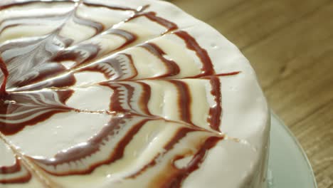 closeup tasty round dessert covering with sugar and chocolate syrup.