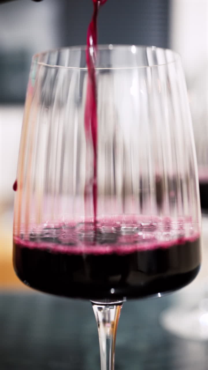Primo piano di vino rosso versato in un bicchiere. Verticale