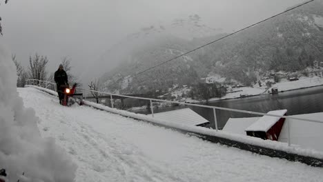 snowfall landscape, lonely man removing snow with snowplow machine - norway