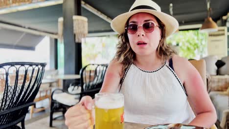 greek cafe lunch: young woman enjoys beer and food