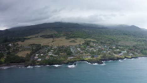 Toma-Aérea-Panorámica-De-La-Ciudad-De-Hana-A-Lo-Largo-De-La-Bahía-De-Hana-En-Las-Laderas-De-Haleakala-En-Maui,-Hawai&#39;i