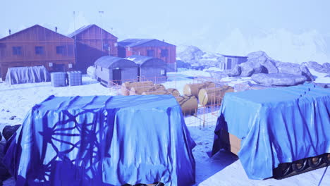 snowy research station with covered vehicles and buildings