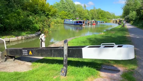 Schöner-Sommertag-Auf-Dem-Kennet--Und-Avon-Kanal-Mit-Bunten-Booten-In-Devizes-England,-Piratenflagge,-Sonniges-Wetter-Mit-Waldbäumen-Und-Grüner-Natur,-4K-Aufnahme