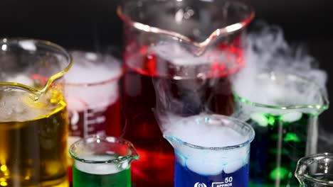 beakers with colorful liquids and dry ice reaction