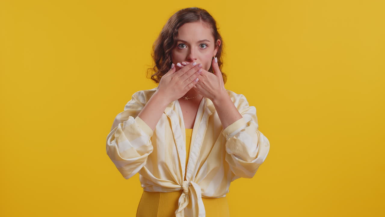 Frightened woman closing mouth with hands refusing to tell terrible secret unbelievable truth