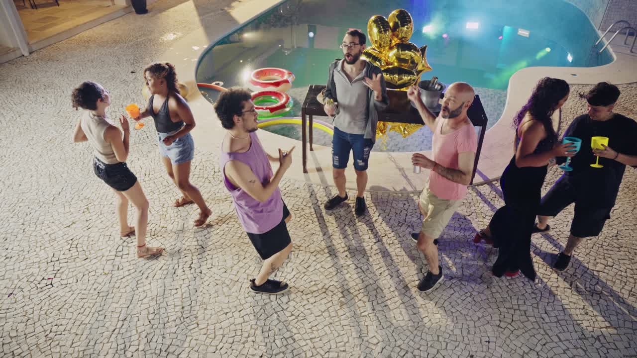 Friends dancing and enjoying a vibrant pool party at night