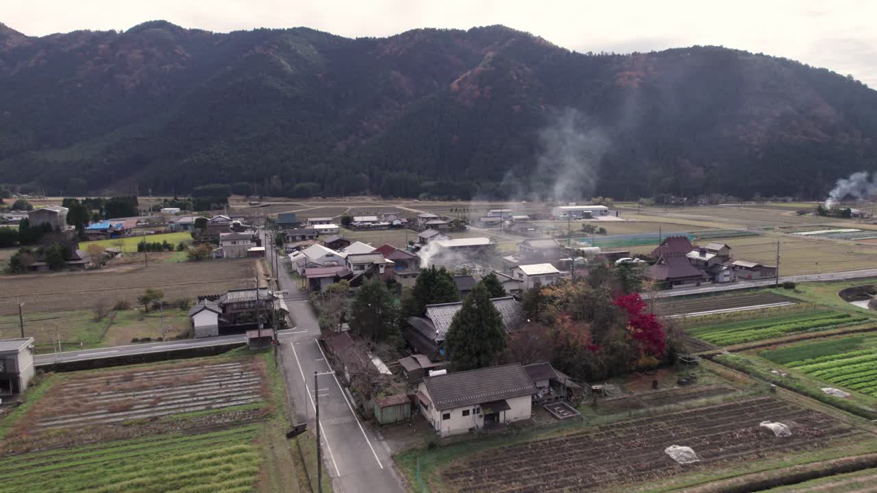 드론을 설치하는 비행기 시골 농경지 케이호쿠 일본의 농경지 도로와 산의 배경을 가진 집