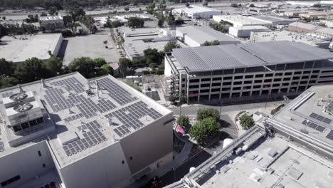 Rising-aerial,-Takeda-Pharmaceutical-company,-solar-panels-on-roof