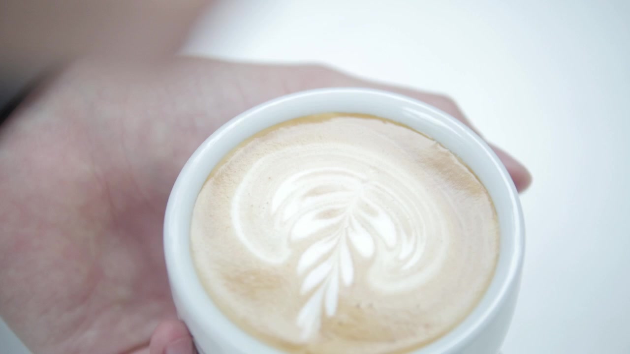 Barista making a latte art rosette shape