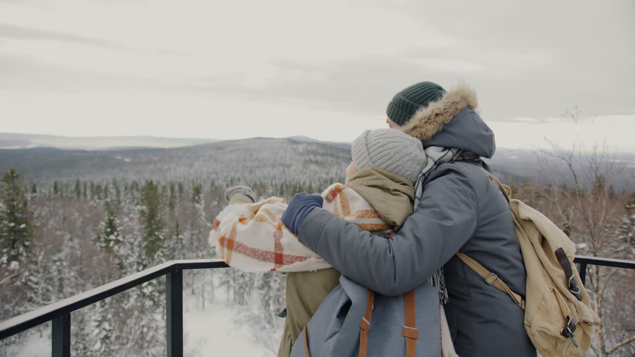 Couple enjoying a winter mountaintop view