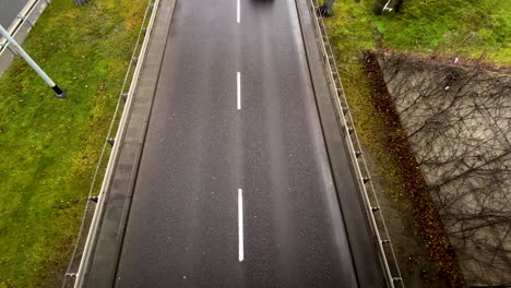 trucks-and-cars-driving-on-a-road-while-a-car-changing-from-right-lane-to-the-left-lane-on-a-black-asphalt-in-Gdynia