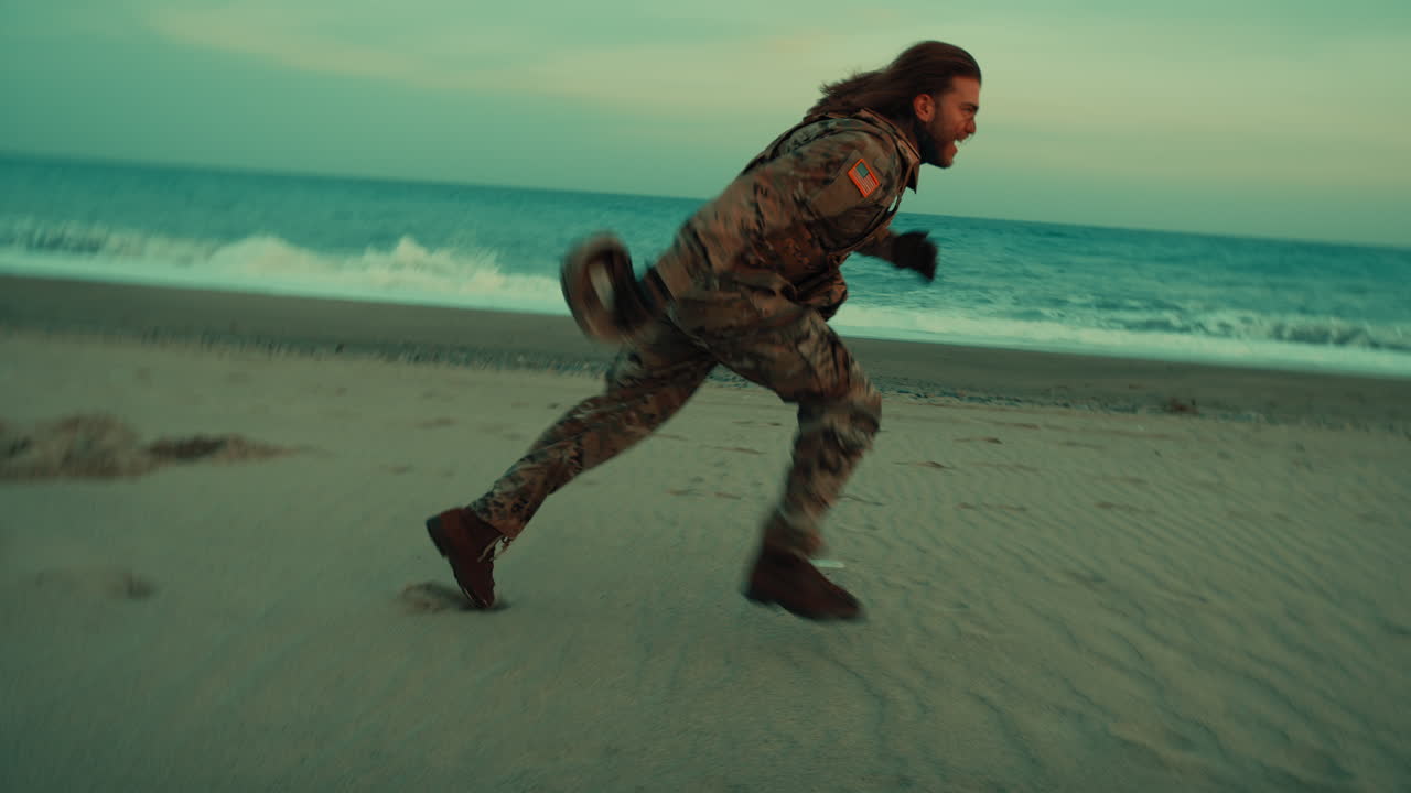 American soldier runs and somersaults on the beach near the ocean in the morning