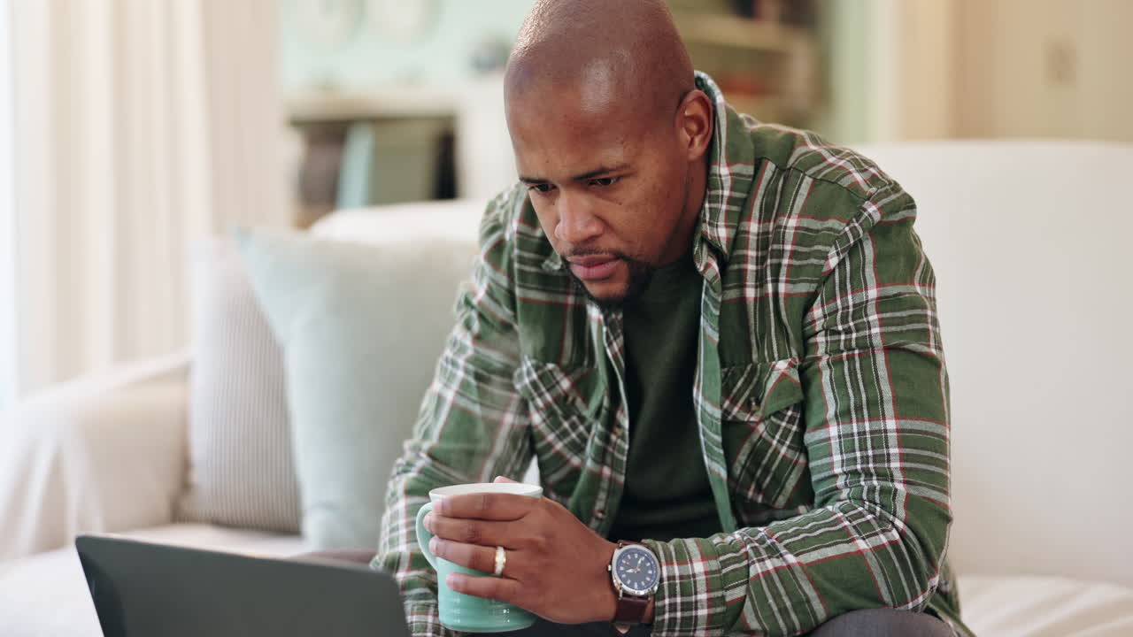 Man working on laptop at home with coffee