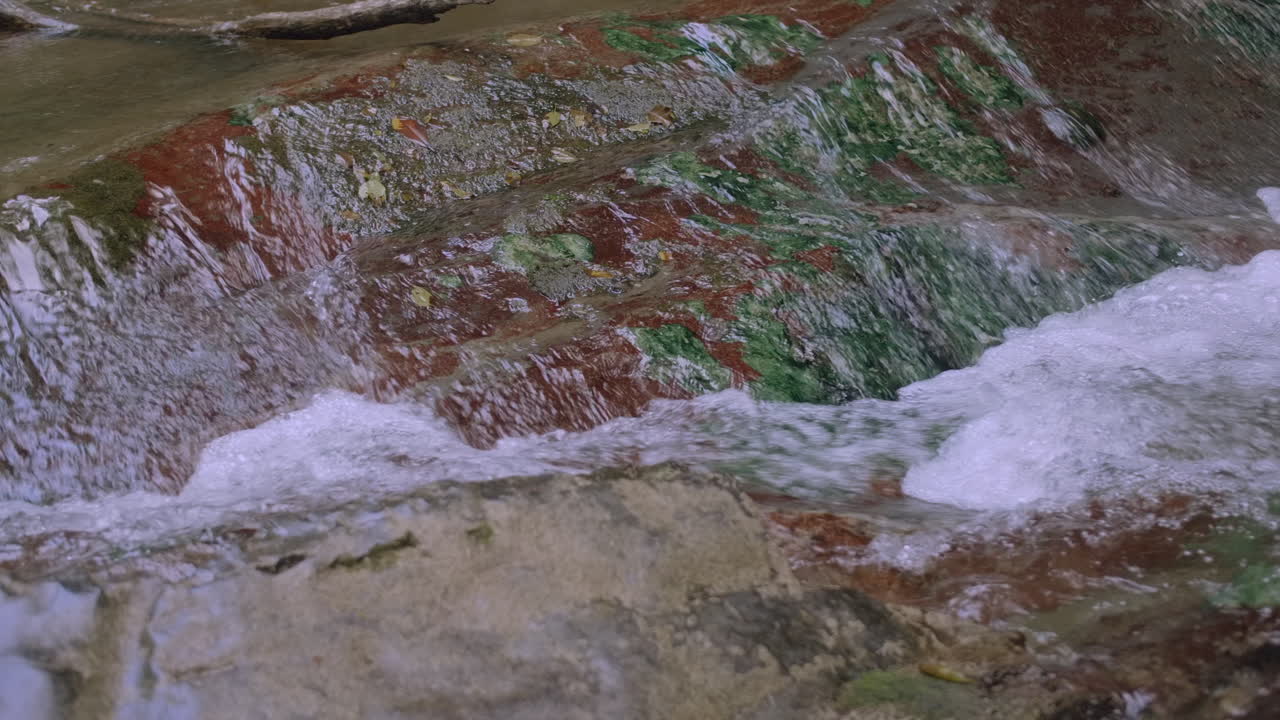 다채로운 바위 위 에 물 이 폭포 로 떨어지는 것