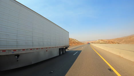 Mientras-Conduce-A-Lo-Largo-De-Una-Carretera-Pasando-Un-Camión-De-Carga-De-Larga-Distancia-En-Un-Día-De-Verano-En-Cámara-Lenta