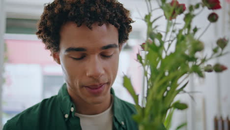black skin guy enjoy flowers bouquet. closeup african man buy roses in shop.