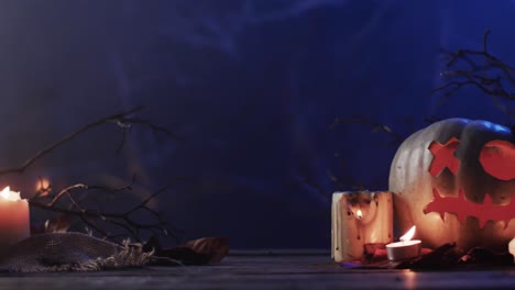 video of halloween carved pumpkins, candles and smoke with copy space on blue background