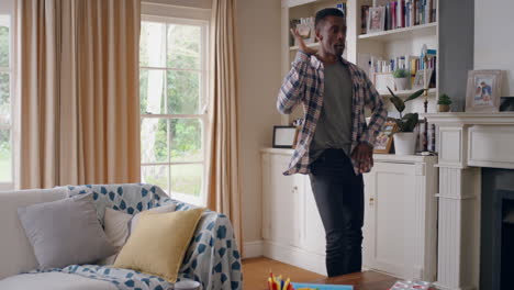 happy african american man dancing at home celebrating success having fun crazy dance in living room enjoying lifestyle freedom on weekend 4k