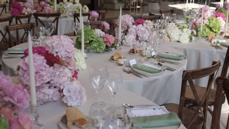 beautifully decorated wedding tables with pastel hydrangea centerpieces, candles, and neatly arranged place settings