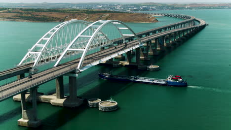 aerial view of a bridge over a bay with a tanker