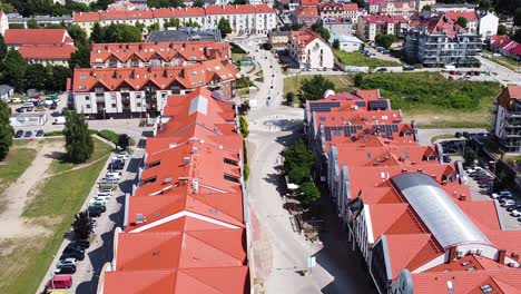 Centro-De-Gizycko-Y-Edificio-Con-Techo-Rojo-En-Un-Día-Soleado,-Vista-Aérea-De-Drones