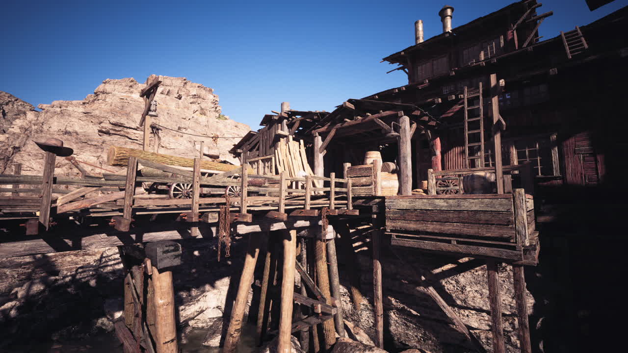 Old wooden dock structure near rocky terrain in bright daylight setting