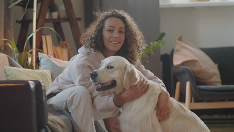 woman hugging a golden retriever dog at home