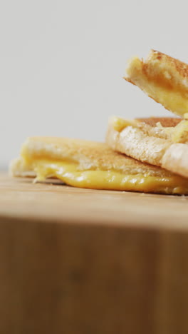 video de primer plano de un sándwich de pan blanco con queso recién preparado en una tabla de madera
