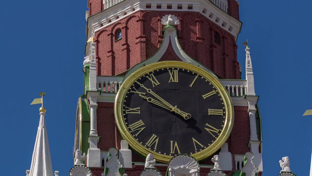 Moscow Kremlin, Red Square. Spasskaya Savior's clock tower timelapse hyperlapse decorated by the red ruby star on the top of it. Blue sky background. UNESCO World Heritage Site